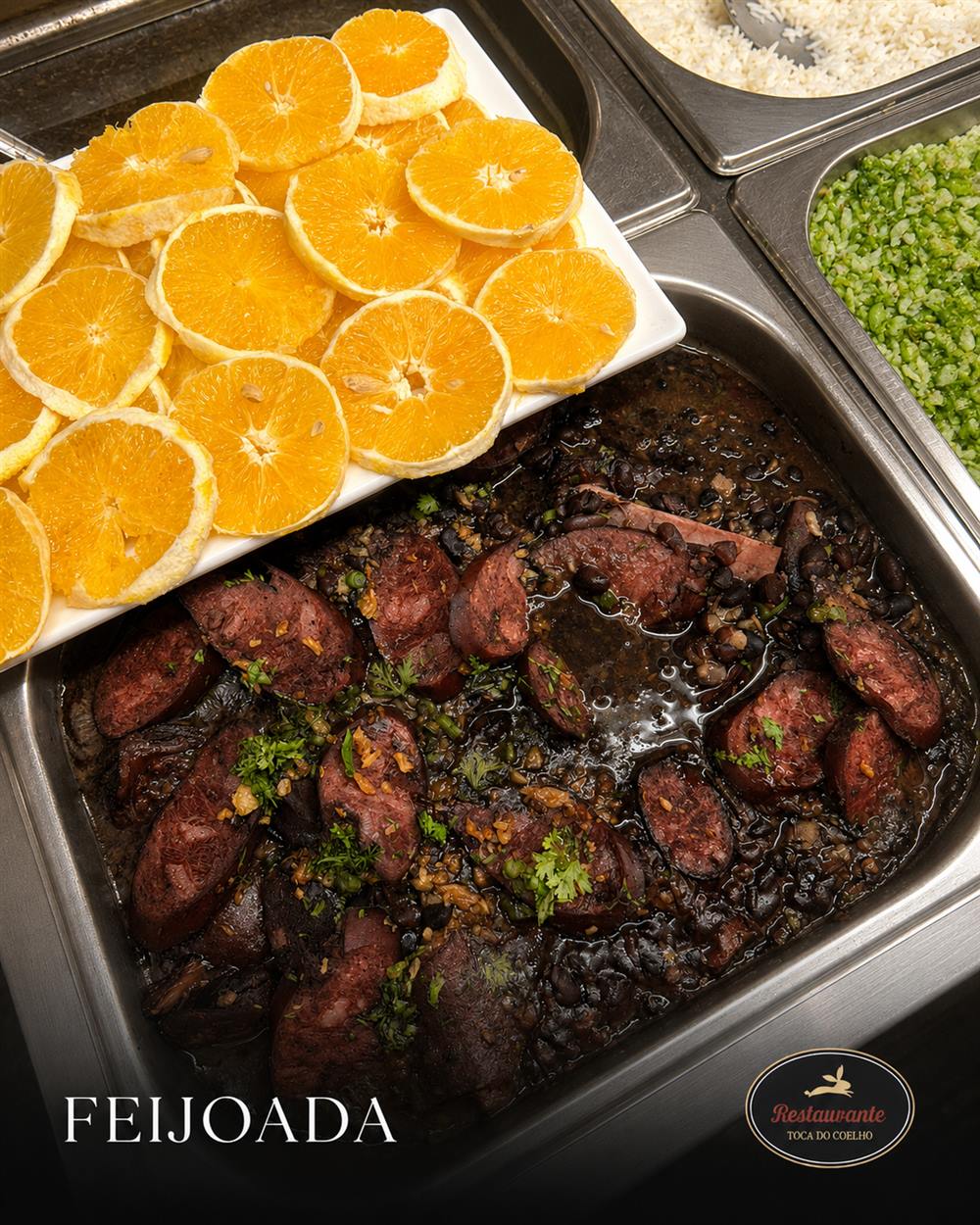Feijoada completa da Toca do Coelho com laranja fatiada, arroz e couve no buffet